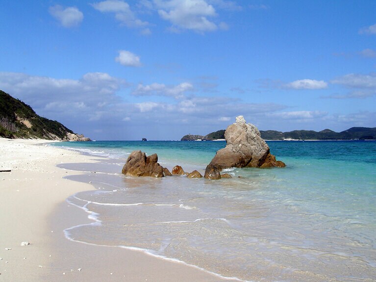 島いちばんの人気ビーチ、ニシバマ。島々が折り重なる風光明媚な景色が広がります。