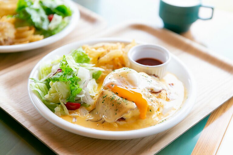 濃厚なチーズソースたっぷりのエッグベネディクト風パンケーキ「チーズ&エッグ」1,250円。