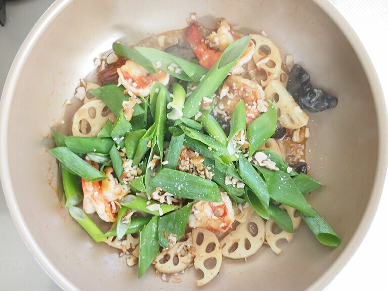 (6) レンコンが柔らかくなってきたら(1)の長ネギ、刻んだ胡桃、［B］の調味料を入れます。