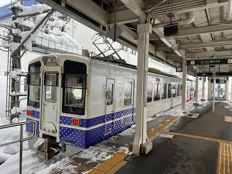 「 研ぎ澄ます、雪の妻有」 ⼭本 茜  「雪の中を走るほくほく線」 待ちに待った新潟旅行は大雪。上越線が運転を見合わせる中、ローカル線のほくほく線が雪の中を果敢に走っていた。ありがたい。