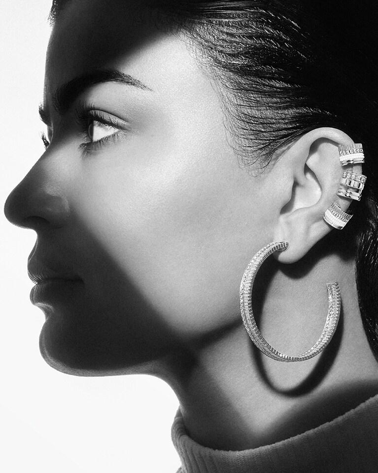 ミラ・アル・ザハラニ。イヤリング(上・下)：キャトル ダブルホワイト シングル クリップイヤリング スモール 423,500円(新作)、イヤリング(中)：キャトル ラディアント オープンロー シングル クリップイヤリング 451,000円(定番アイテム)、ピアス：キャトル ラディアント フルパヴェ ダイヤモンド フープイヤリング 10,164,000円(新作)／ブシュロン クライアントサービス。