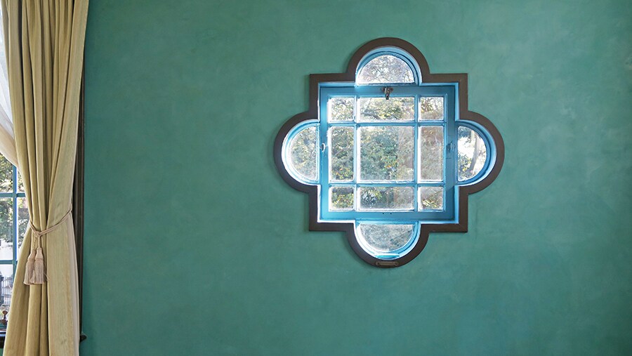 フレスコ画技法のブルーの磨き壁に、四葉のクローバーのような形のクワットレフォイルの小窓が印象的。