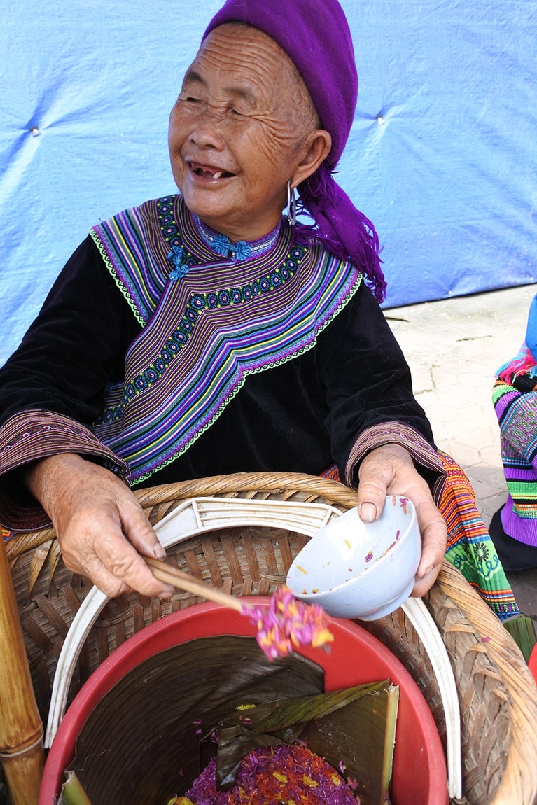 鮮やかに染めた、もち米を売るおばあさん。