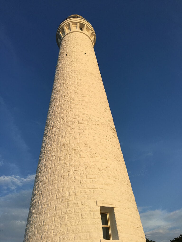 夕映えに染まる日本一背高のっぽな灯台。100年以上、夜の海を照らし続けている。