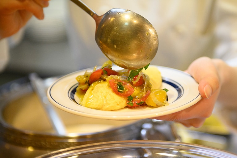 ふんわりトロトロに焼かれたオムレツ。バジル風味のフレッシュトマトソースで。