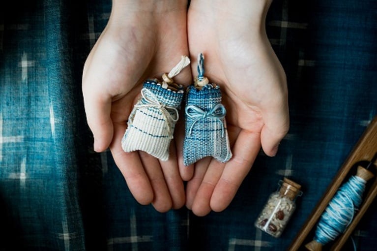 神司の祈祷を受けた五穀と塩を詰めた瓶の外袋を織り上げ、お守りが完成となる。