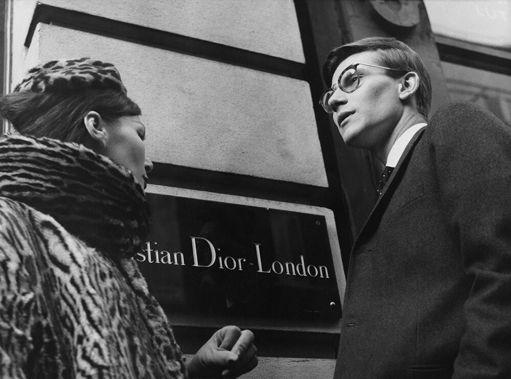 1958年11月11日、ロンドンのクリスチャン・ディオールの前に立つイヴ・サンローラン。© Popperfoto/Getty Images