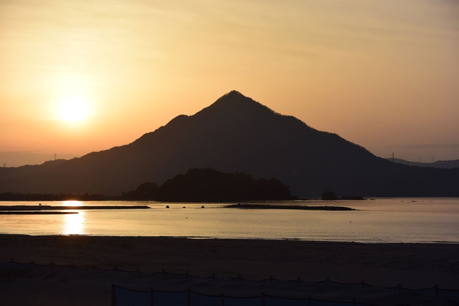 若狭富士が際立つ、若狭和田ビーチにサンセット。海に金色の太陽の道がのびています。