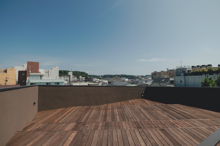屋上には、約48㎡のウッドデッキが広がる。鎌倉の空を⾒上げながら寝転んだり、壁にもたれたり、思い思いのひとときを。