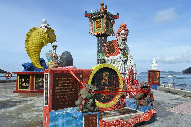 月からやってきた愛と結婚の神様は、赤い糸でぐるぐる巻きに。背後の黄色の魚の口に皆、コインを投げ入れようとします。