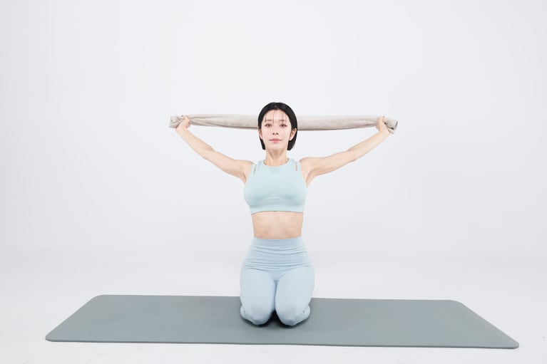 【STEP.3】5秒ほどかけて息を丁寧に吐く。タオルを軽く外側に引き合って5秒キープ。鎖骨が後ろに回って胸が自然に開く感覚で