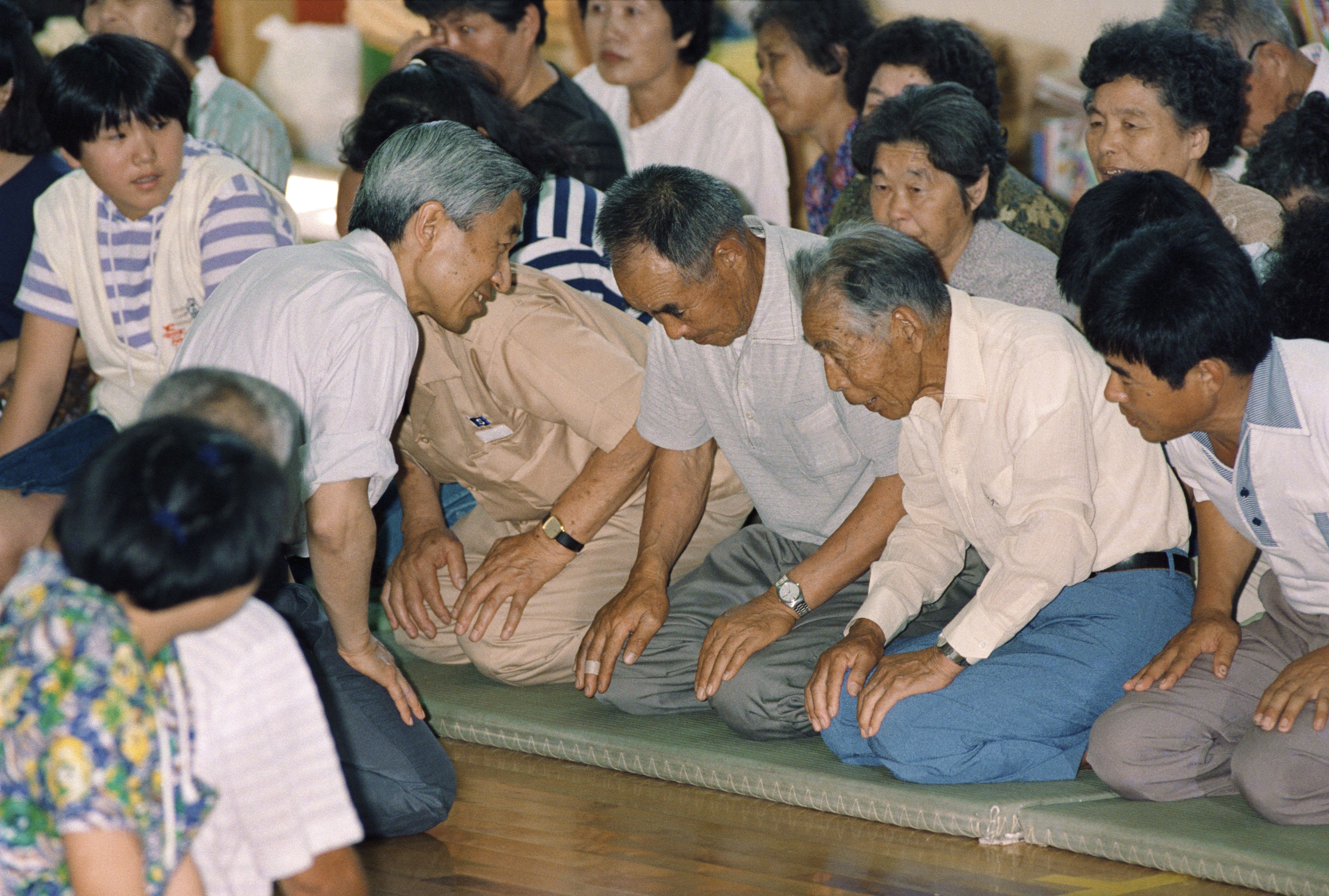 雲仙普賢岳噴火で、中学校の体育館に避難している住民と膝を交える天皇陛下（写真は1991年、当時）　©時事通信社