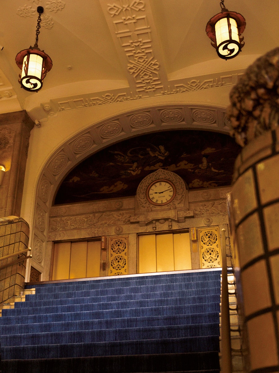 本館2階ザ・ロビーへ向かう大階段はホテルのシンボル。壁などの装飾、東洋の趣がある灯りは開業当時のまま。