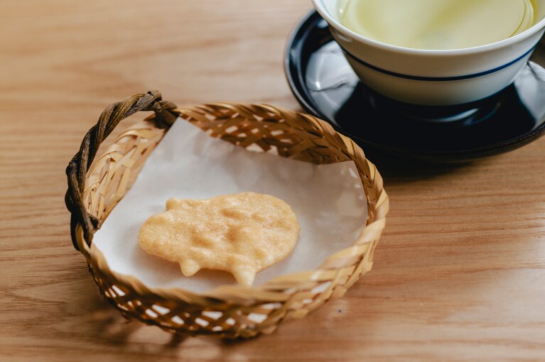 煎茶と共に出される「トントン拍子」は、国産うるち米とフランスの塩を使ってパリッと焼き上げたオリジナル煎餅。器も旧店と同じものを再現。お茶は神楽坂「楽山」製。