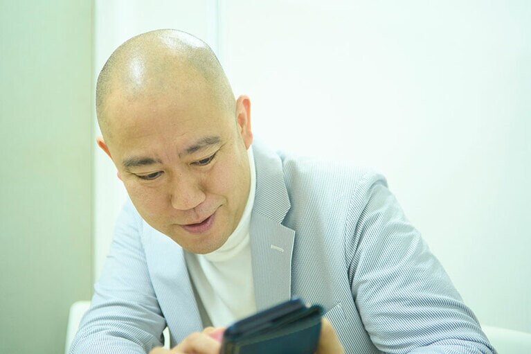 取材中、金魚の写真を見せてくれながら話をするナダルさん。