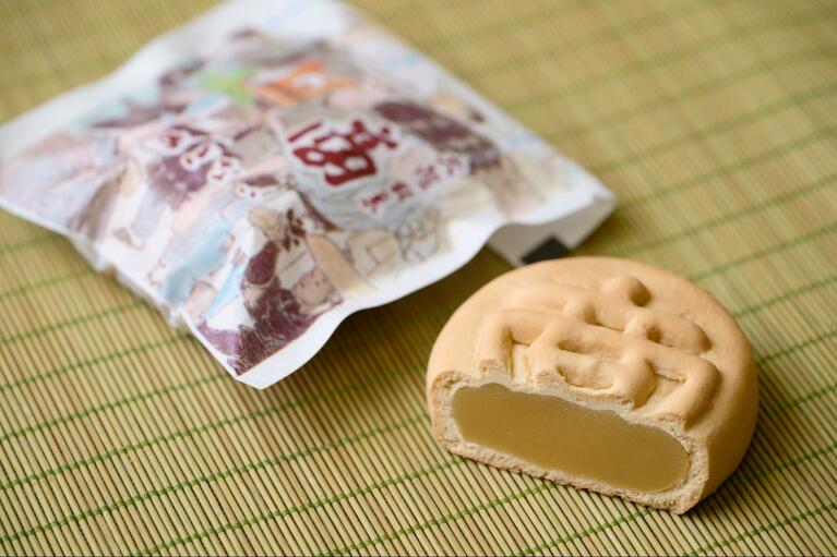 「御菓子司 絹笠」の原点である、代表銘菓「商（あきない）」。舌触りが滑らかな黄味餡を、甘味をおさえた生地で包んでいる。こちらもぜひ。