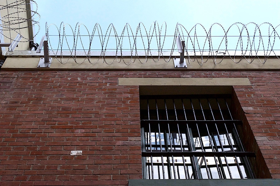 分厚い壁と鉄格子、建物上部には鉄条網と、刑務所の雰囲気がムンムン漂う。