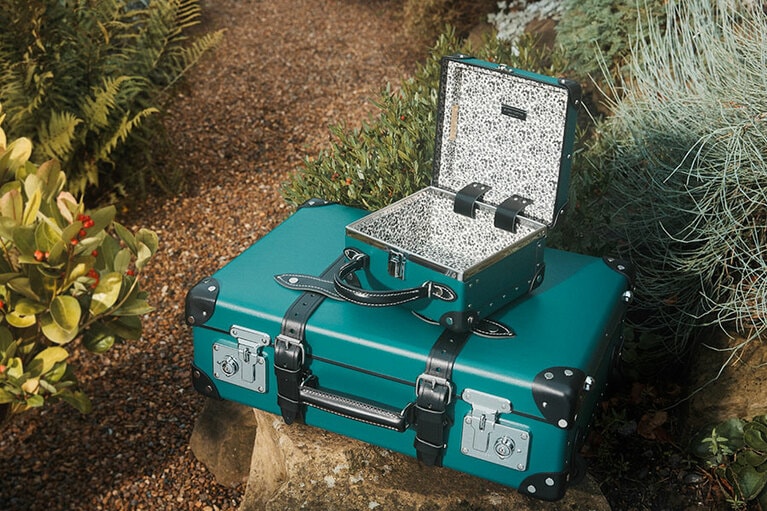 上段：“ナイトタイムガーデン”ミニトランク (W20×H20×D11cm）120,000円、下段：“ナイトタイムガーデン” 20インチ トロリーケース(W55×H42×D18cm) 225,000円。