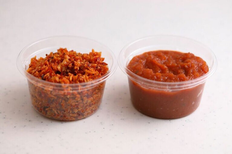 右が、麺の上にかかっているサンバル。唐辛子やトマトで作るフルーティーな味で、料理に深みを出す。左が、卓上に常備されているチリフレーク。唐辛子、干し海老、葱などを油で香ばしく炒めたもので、小さじ1/2ほど加えると、額にジワッと汗をかく現地の味に。