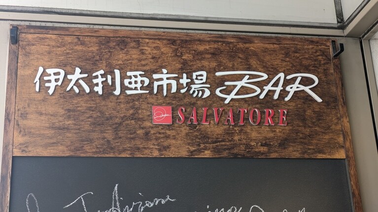 新宿三丁目「伊太利亜市場BAR」。伊勢丹の裏の小道を渡った先のビルの2階にある。近くの花園神社で所持金のすべてを賽銭箱に投じ、イタリア特集号の完売を祈ったのであいにく持ち合わせがなく、店に入ってはいないが、活気溢れるムードの中、美味しいワインとともに素材を生かした料理が堪能できるらしい。