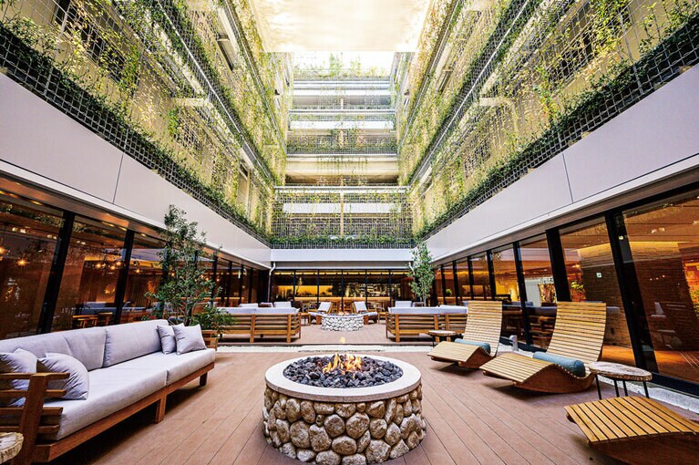 吹き抜けの空間を覆う緑が印象的なラウンジエリア。