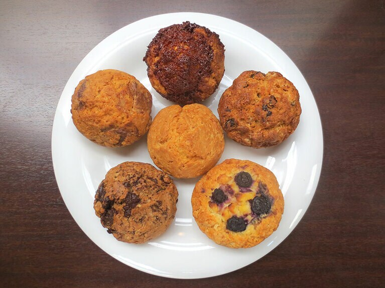 スコーン6種。上より時計回りに「キャラメル」「クルミとレーズン」「ブルーベリーとチーズケーキ」「チョコレート」「ホワイチチョコとレモン」、中央「プレーン」。各200円。