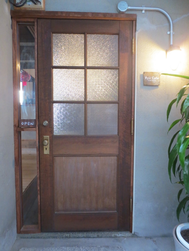 古いドア横に小さな看板。