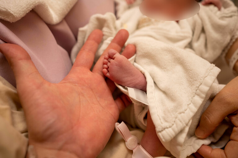 産後に三人で記念撮影（本人提供）