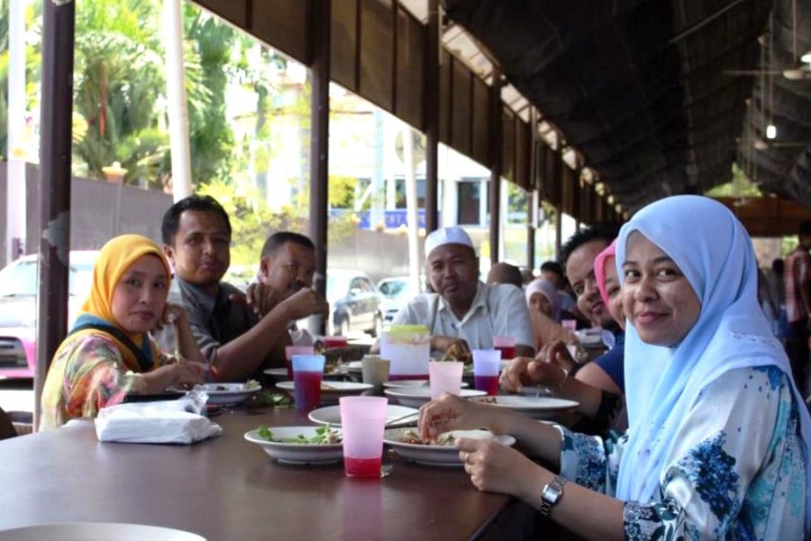 マレーレストランにて笑顔でテーブルを囲むマレー系のグループ。マレーシアでは大人数でごはんを食べる光景がよく見られる。