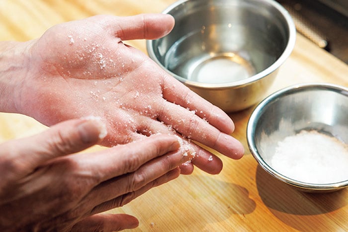 両方の手を塩水でぬらし、手のひらに粗塩をつける。