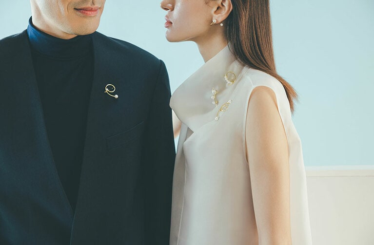 左男性)「ア ファイン バランス ブローチ B4439」(YG/あこや真珠) 363,000円。右女性上から)「ア ファイン バランス ブローチ B4437」(YG/あこや真珠) 363,000円、「ア ファイン バランス ブローチ B4438」(YG/あこや真珠) 385,000円、「ア ファイン バランス ブローチ B4440」(YG/あこや真珠) 363,000円。