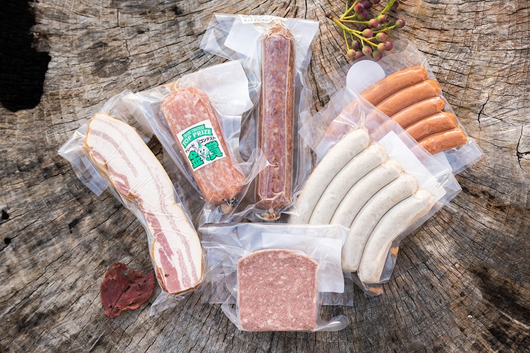 左上から時計まわりに、「〈脂身がうまい〉燻し上げベーコンブロック」1800円、「たまとろサラミ」1620円、「ヴィンツァーサラミ」1920円、「チョリソー」720円、「焼きソーセージ」720円、「田舎パテ」1320円。