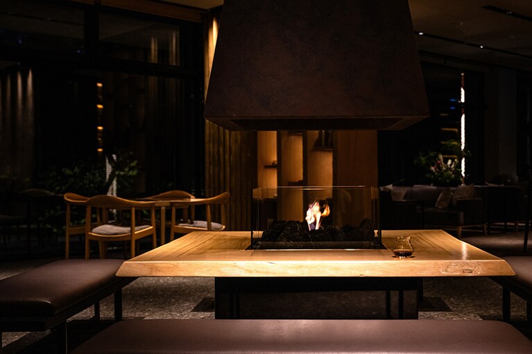 暖炉に炎がゆらめくラウンジでバータイムを。