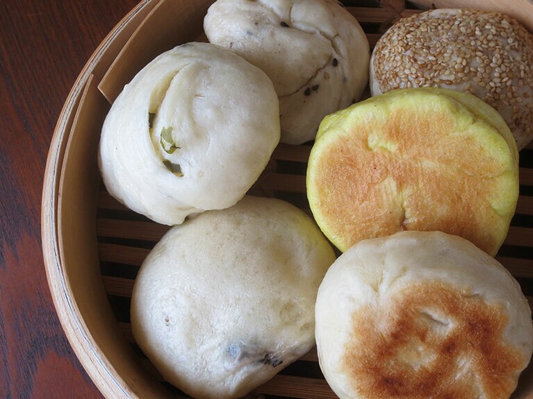 点心「ごはんのわ」。右上から時計回りで「中華ミートパイ」400円、「ターメリックスパイスまん」350円、「焼き黒豚まん」350円、「丹波黒豆」300円、「巻きねぎまん」300円、「黒ごま」300円。