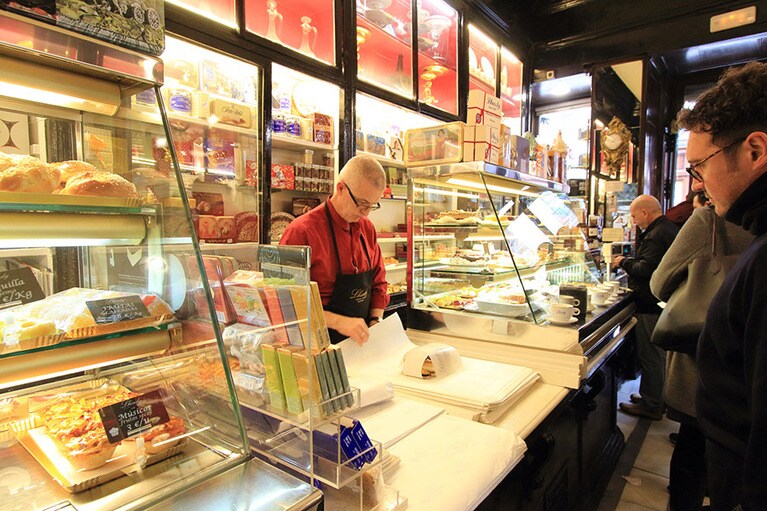 テイクアウトのコーナーの店員さんは、目にも止まらぬ早さでパイを紙で包んでいく。