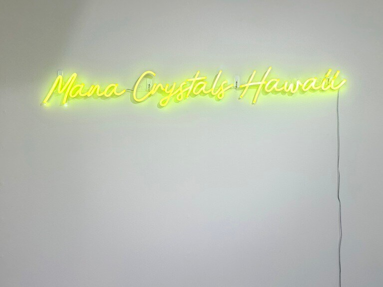 シンプルな店内にかかる蛍光カラーのショップ名のネオン。