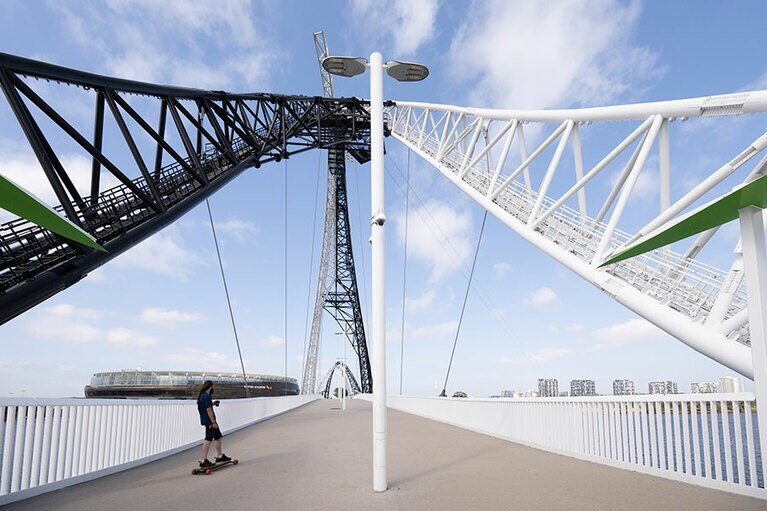 下から見上げるブリッジとオプタススタジアム。