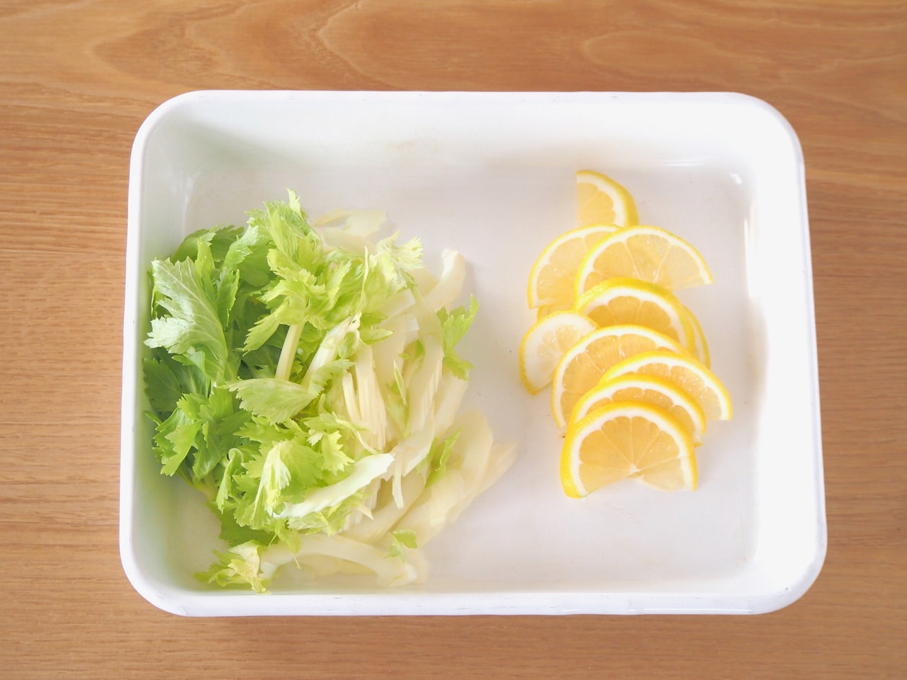 セロリは斜めの薄切りに。レモンは半月の薄切りにする。