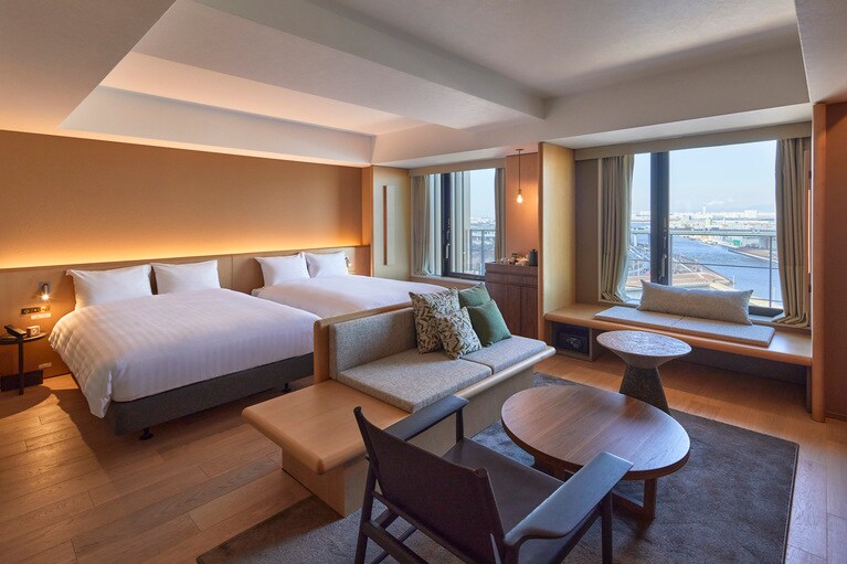 客室の一例「ウォーターフロント プレミアスイート」。窓の外には、刻々と移りゆく旧堺港の景観が広がる。