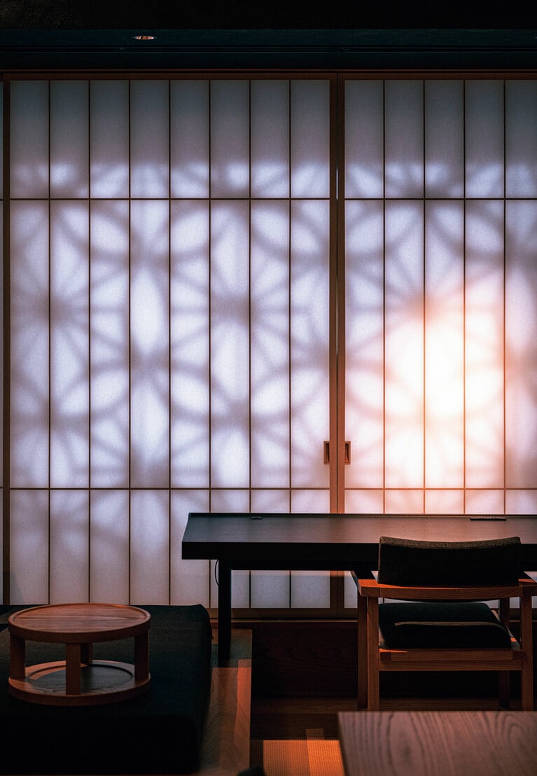 「お茶の間ラウンジ」の窓際席。午後の光が障子に映し出す外壁の麻の葉くずし模様は、まるで光のアート。