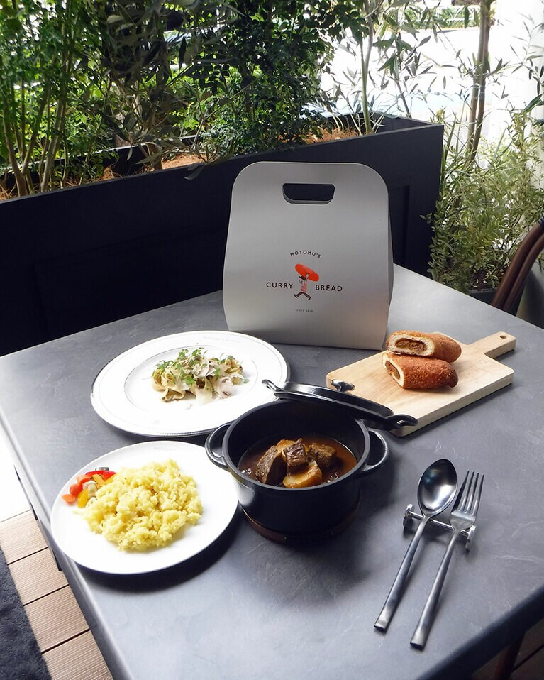 手前：MOTOMU'S A5ランク黒毛和牛のスープカレー(サラダ、クミンライス、ドリンク付) 2,000円、奥：MOTOMU'S 白のラグー タリアテッレ(サラダ、パン、ドリンク付) 1,800円、右：もとむのカレーパン 2本セット800円／MOTOMU'S BY KAPPA ※すべて税込