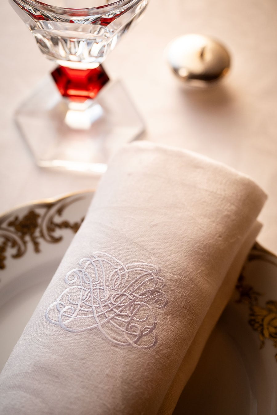 エレガントな紋章が入ったテーブルクロス。ヴェルサイユ宮殿の晩餐会をイメージし、グラス、カトラリーすべてが選び抜かれている。食事はゲスト全員が同時刻にスタートするスタイル。