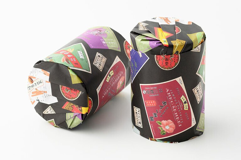 三松堂「落花煎餅」1,300円 (120g入り)、「冨貴童子」1,600円 (20枚入り)。包装紙には、レトロ菓子シリーズの全ラベルがプリントされている／秋田県