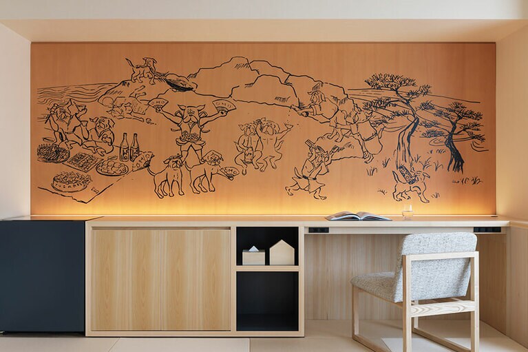 鳥獣戯画っぽいタッチの土佐犬が「おきゃく」を楽しんでいる、客室のウォールアート。