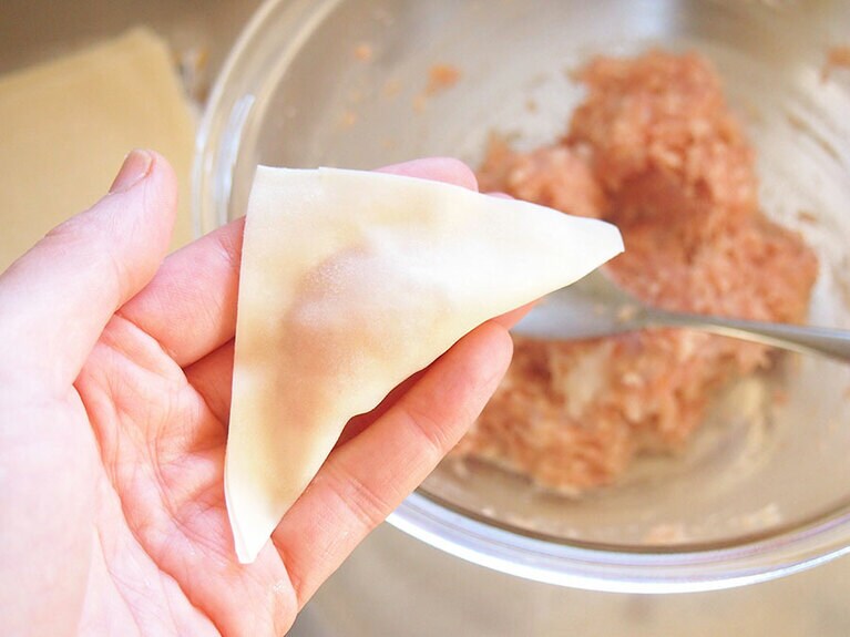 (4) ワンタンの皮の周りに水を塗って、仕上がりが三角になるように畳みます。