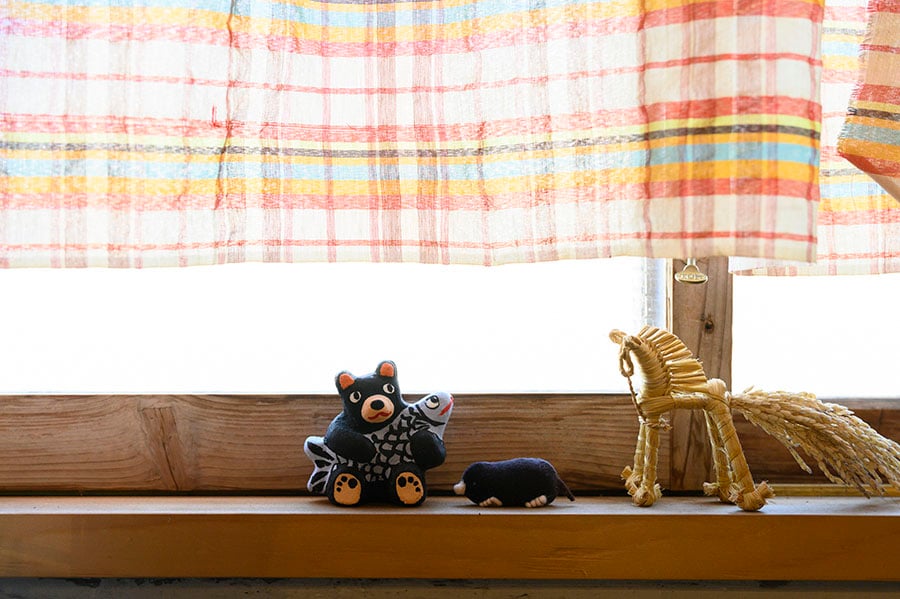 小さな窓には、熊の土人形や大崎地区絞張集落に伝わる絞張馬と呼ばれる藁細工が。