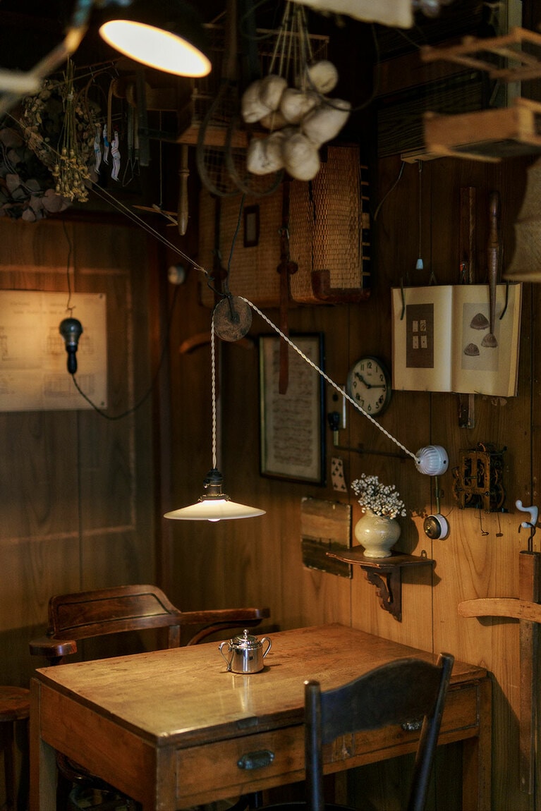 壁に本をディスプレイ。開いたページを押さえているのは、フランスのアンティークで「革手袋の指先を伸ばす道具」。