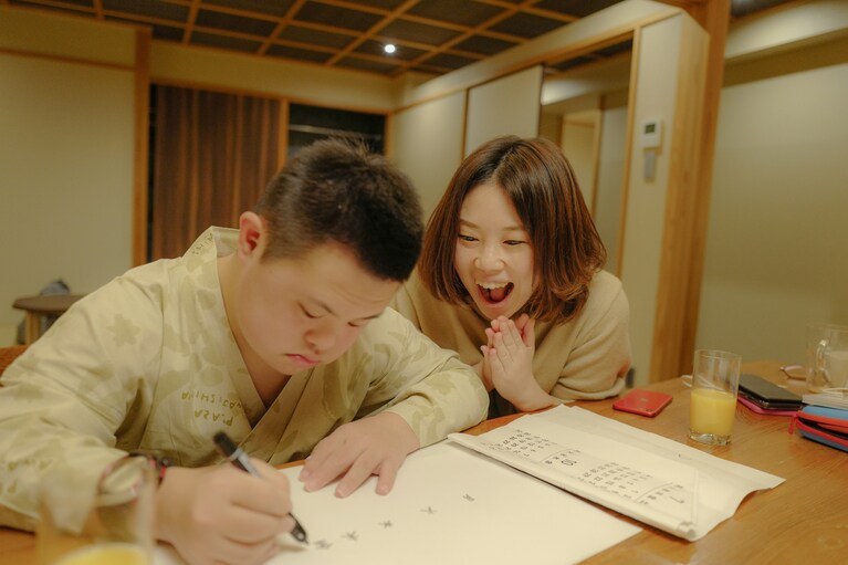 カレンダーの文字を書く良太さんと奈美さん。