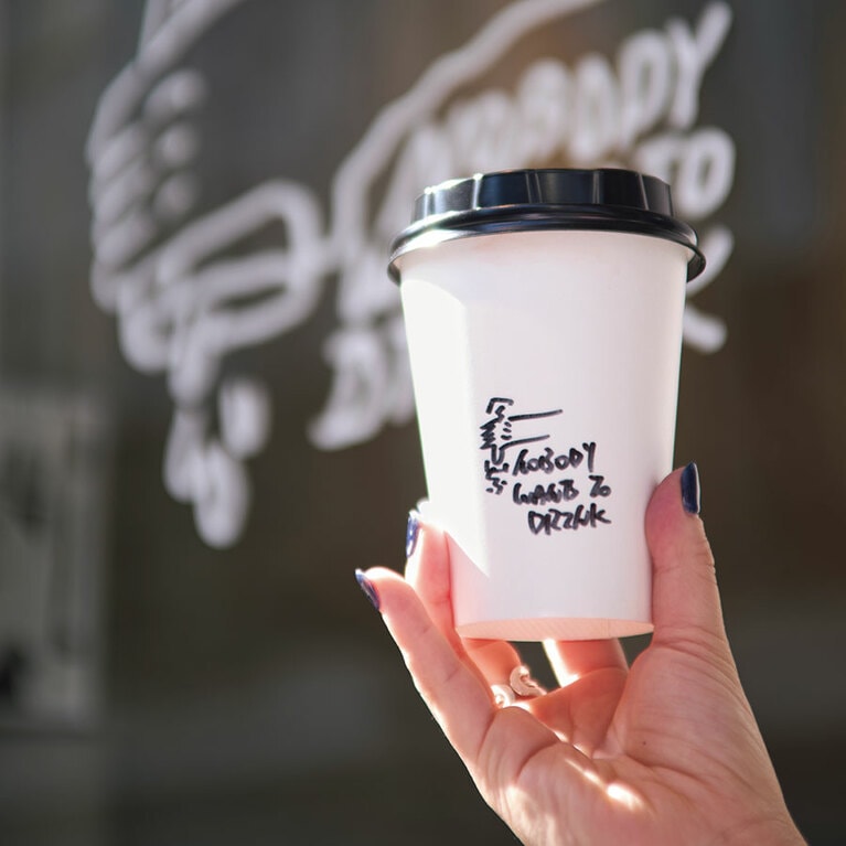 カップには手書きのイラストが。カフェラテ100元。／KWON SAEM COFFEE（クォン サエン コーヒー）