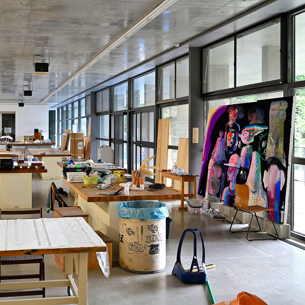 アーティストが制作する創作棟は、長さ100mの開放感ある平屋。写真の絵画は、しまうちみか氏の作品。